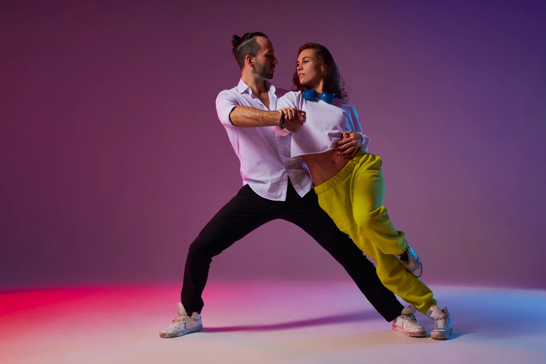 A couple dancing in a close hold under dramatic plum studio light